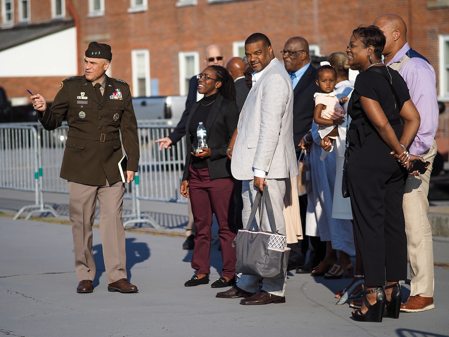 An Army officer gestures as he talks to about six civilians