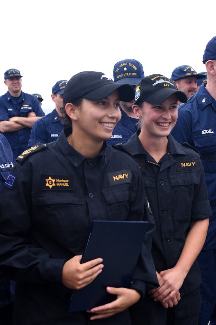 Leading Chef Monique Manuel and Able Chef Alice Wyatt of the Royal New Zealand Navy stand among the crew of U.S. Coast Guard Cutter Stratton (WMSL 752) after Manuel received a surprise advancement in rank while underway April 18, 2023. Manuel and Wyatt joined the Stratton crew for a Western Pacific patrol advancing the partnerships between the United States and New Zealand. (U.S. Coast Guard photo by Petty Officer 2nd Class Michael Clark)