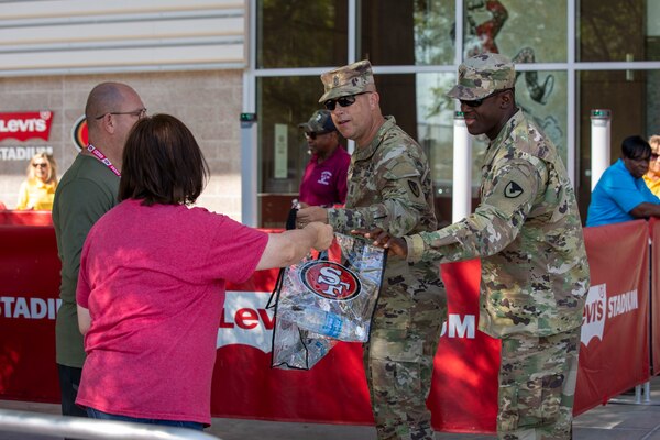Julie DeMaria, hands out gift bags to service members at the 49ers Training Camp on Friday, Aug. 4, 2023.