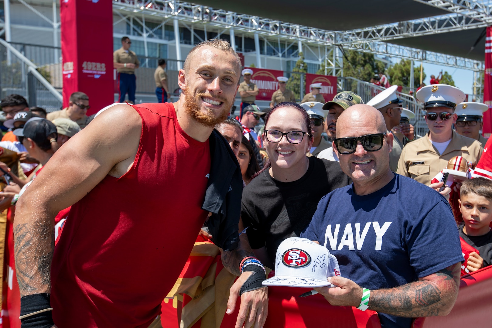 George Kittle, left, tight end for the San Francisco 49ers, poses for a photo with employees April Bendickson and Christopher Loyd at the 49ers Training Camp.