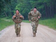 Spc. Jason Riley, left, and Sgt. Jason Paglia are pictured during the ruck march at Army Materiel Command's 2023 Best Squad Competition at Fort Novosel, Alabama. (Adam Sikes)