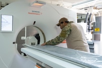 A biomedical equipment technician at the U.S. Army Medical Materiel Agency’s Medical Maintenance Operations Division in Tracy, California, performs maintenance on a computed tomography machine. (Photo Credit: Katie Ellis-Warfield)