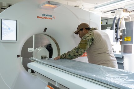 A biomedical equipment technician at the U.S. Army Medical Materiel Agency’s Medical Maintenance Operations Division in Tracy, California, performs maintenance on a computed tomography machine. (Photo Credit: Katie Ellis-Warfield)