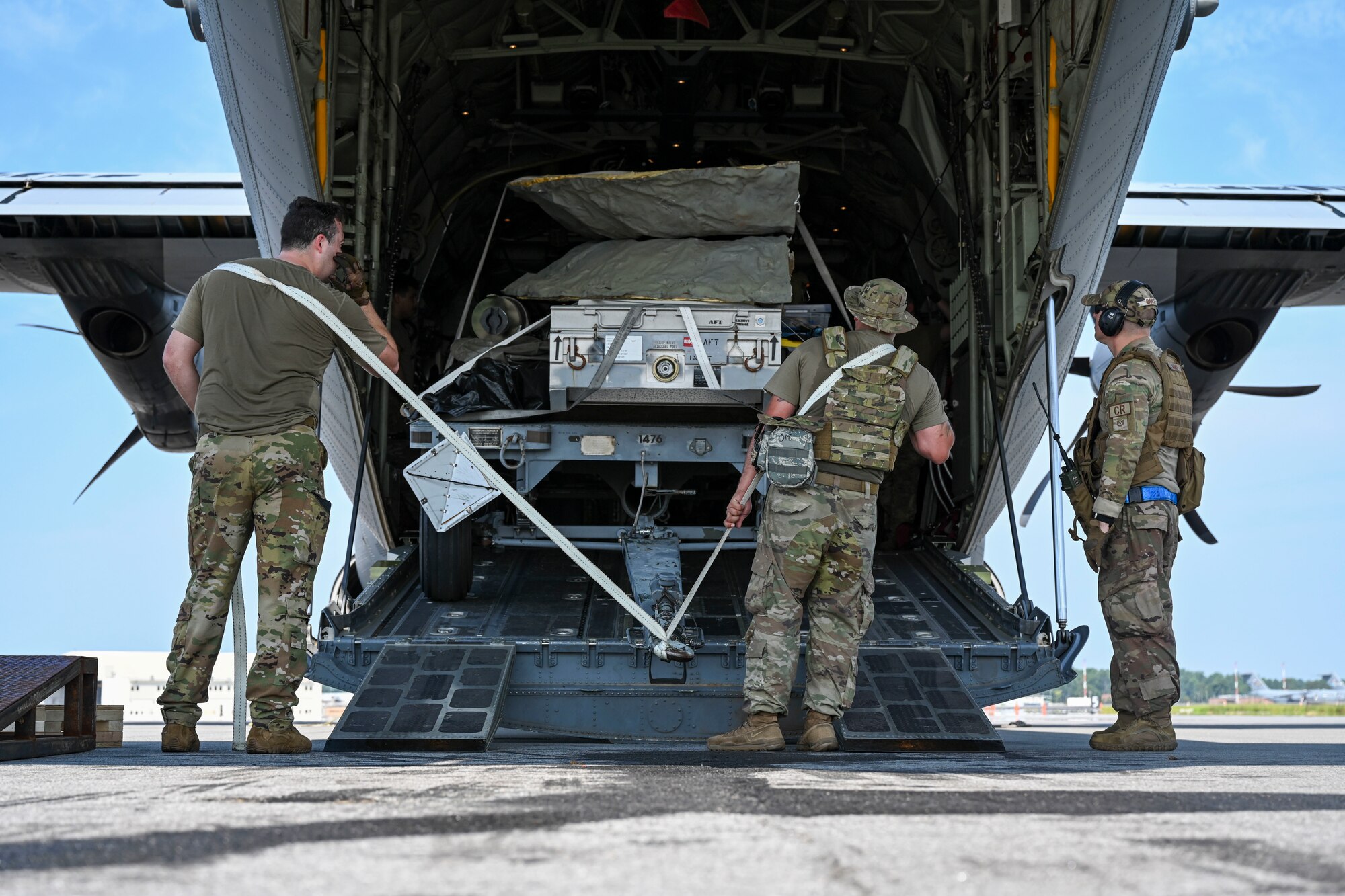 Loadmasters with the 41st Airlift Squadron load equipment vehicles onto a C-130J Super Hercules