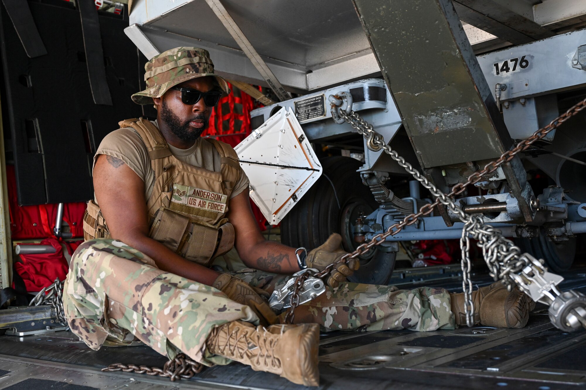 An Airman with the 4th Maintenance Group secures a vehicle to a C-130J Super Hercules