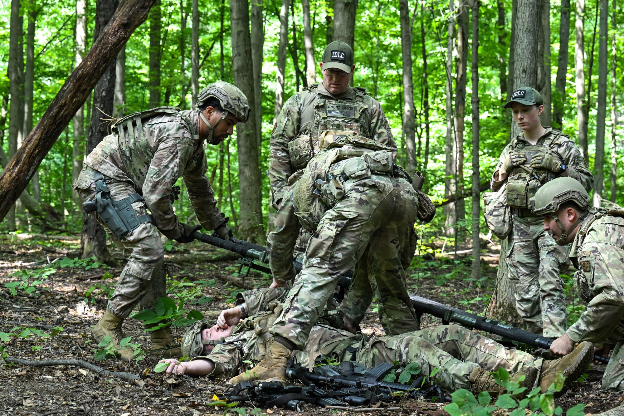 Integrated Defense Leadership Course cadre members observe students during a static defense training exercise involving tactical combat casualty care on July 24, 2023, at Camp James A. Garfield Joint Military Training Center, Ohio.