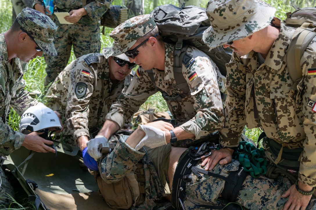 U.S. service members and German Army soldiers conduct medical aid on a simulated casualty, during Mountain Medicine (MMED) 1-23 at Marine Corps Mountain Warfare Training Center, Bridgeport, California, July 21, 2023. MMED challenges service members with various medical and technical problems common to mountainous environments in preparation for future conflicts in austere terrain. (U.S. Marine Corps photo by Lance Cpl. Anna Higman)