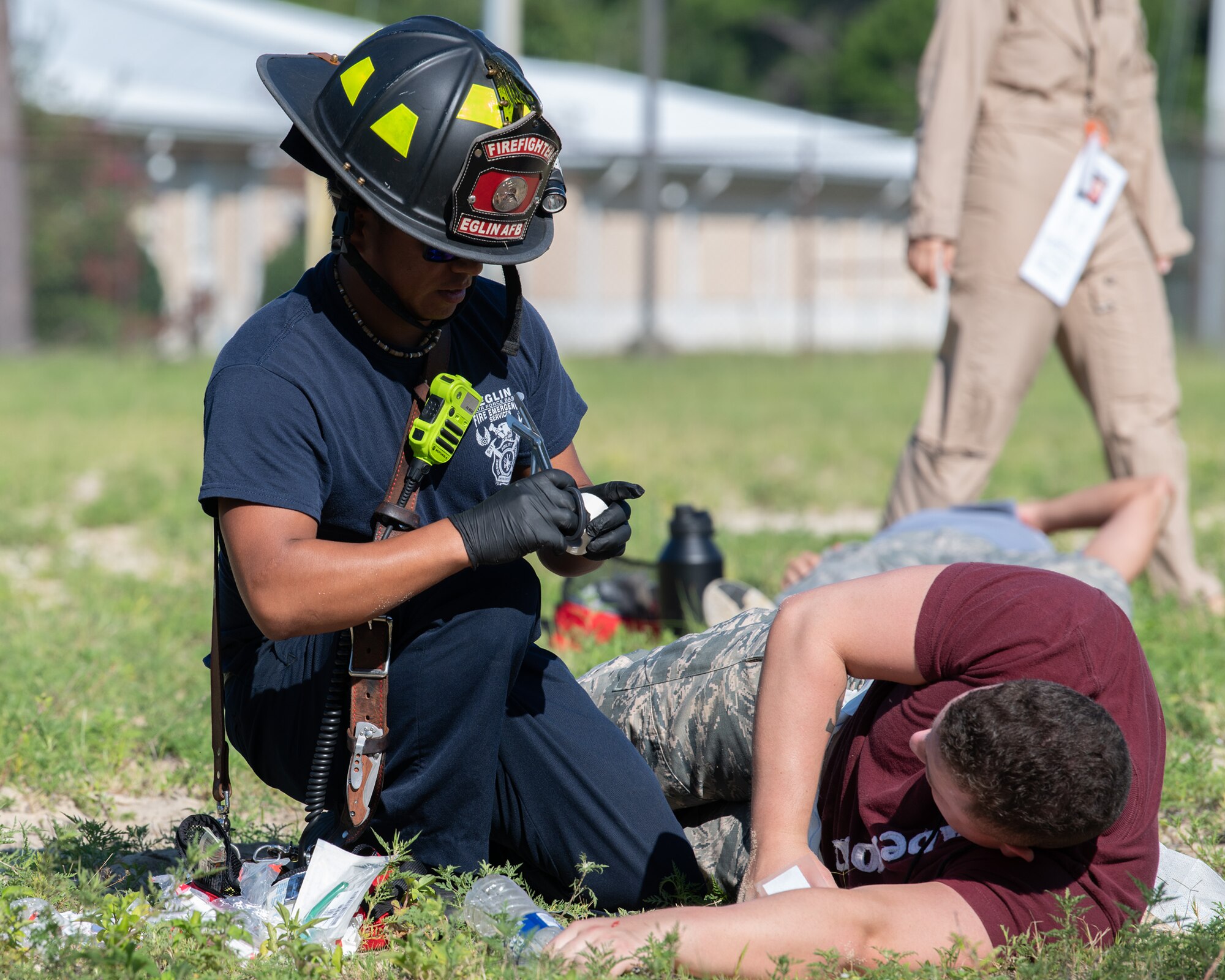 Michael Lumbreras, 96th Civil Engineer Group firefighter, treats a mock casualty during a simulated explosion as part of a training exercise.