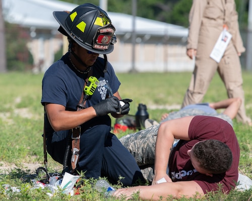 Michael Lumbreras, 96th Civil Engineer Group firefighter, treats a mock casualty during a simulated explosion as part of a training exercise.
