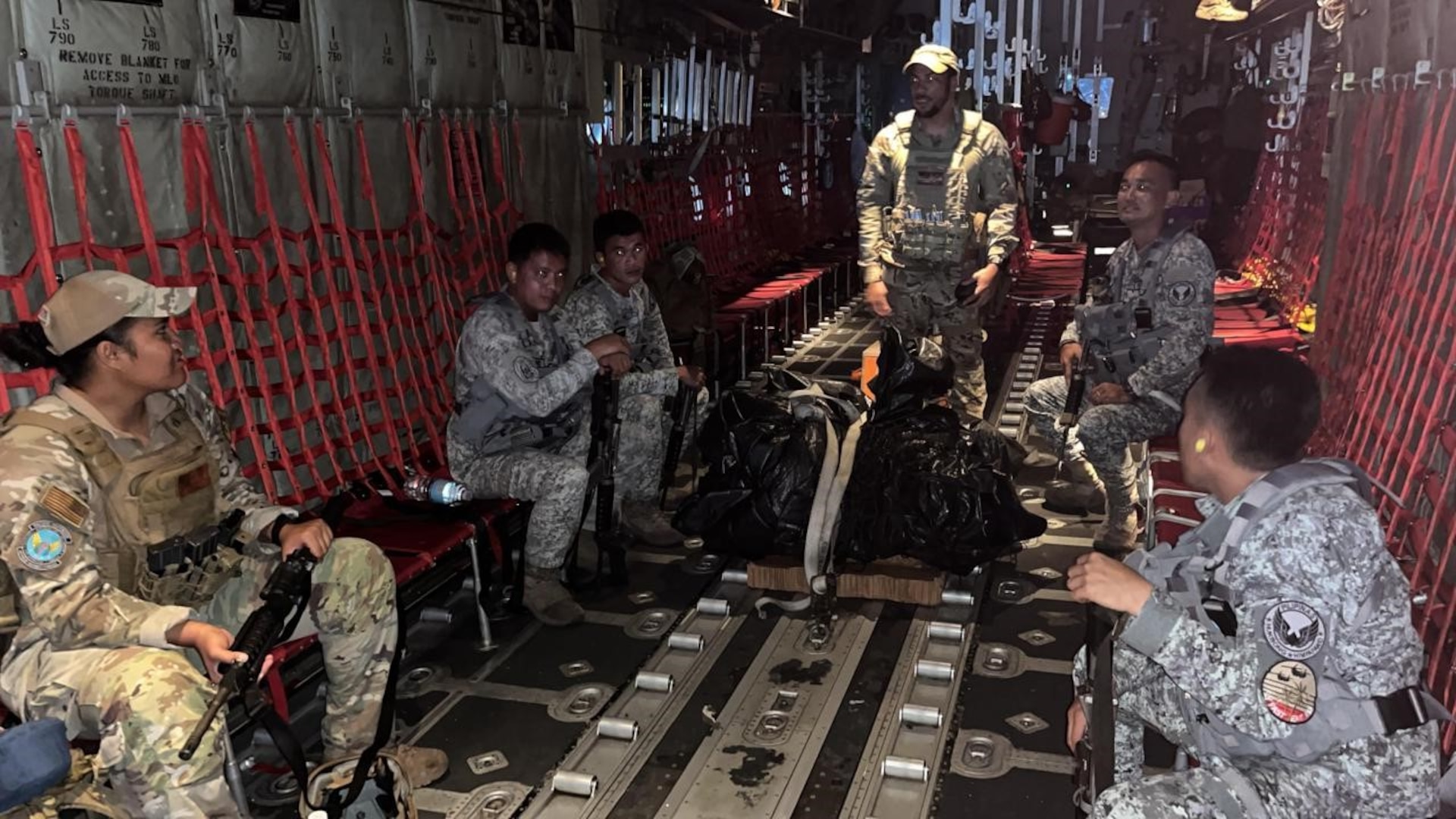 U.S. Air Force Staff Sgt. Emmanuel Nieves, an instructor assigned to the 736th Security Forces Squadron, Andersen Air Force Base, Guam, briefs members of the U.S. Air Force and Philippine Air Force during a nighttime operation cargo drop on a C-130 Hercules en route to Tacloban Airport, Philippines, July 13, 2023. During Cope Thunder 2-23, members of the USAF and PAF took part in a subject matter expert exchange in tactics and operation methods, which allow for enhanced future operations, ensuring a free-and-open Indo-Pacific. (Courtesy Photo)