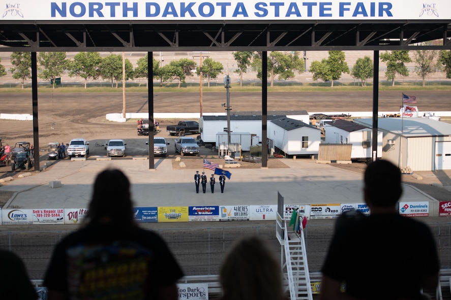 Minot Air Force Base Honor Guardsmen perform at the North Dakota State Fairgrounds during a racing event at Minot, North Dakota, July 9, 2023. The Honor Guardsmen presented the colors while the national anthem played before the race. (U.S. Air Force photo by Airman 1st Class Trust Tate)