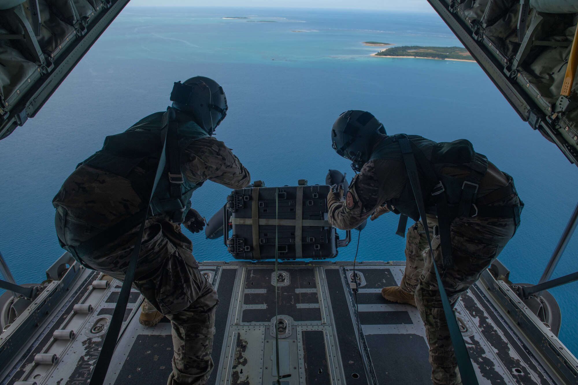 U.S. Air Force HC-130J Super Hercules loadmasters assigned to the 79th Rescue Squadron from Davis-Monthan Air Force Base drop rescue equipment off the ramp during open water rescue training off the shores of Okinawa, Japan, July 20, 2023. The squadron worked with Kadena’s 31st and 33rd RQS, conducting a realistic training scenario for crews to enhance their knowledge on rescue operations. (U.S. Air Force photo by Senior Airman Cedrique Oldaker)
