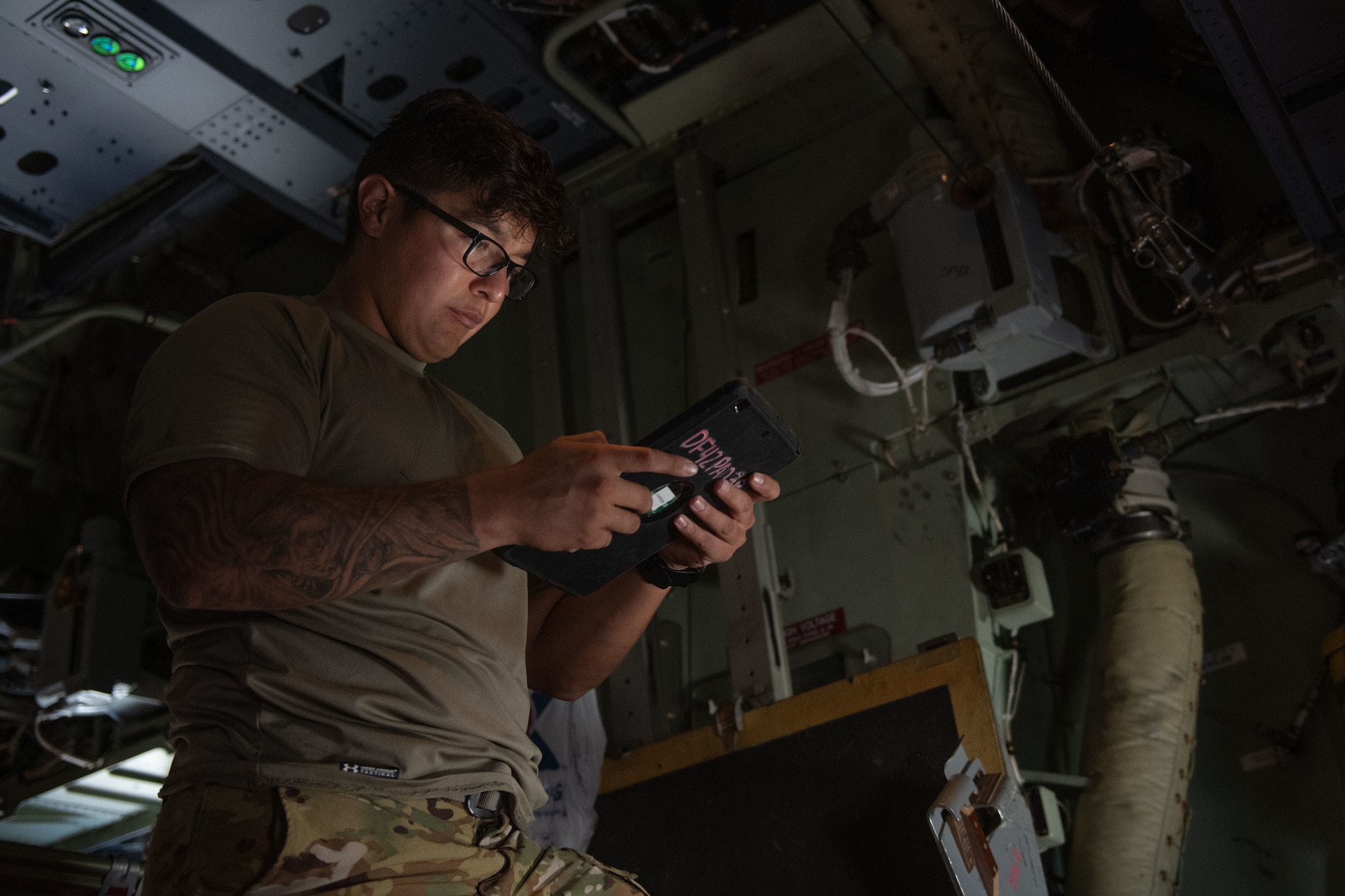 U.S. Air Force Staff Sgt. William Archuleta, 31st Rescue Squadron flying crew chief, checks technical orders during preflight inspections at Kadena Air Base, Japan, July 20, 2023. The 31st RQS conducted water rescue training with the 33rd RQS and the 79th RQS from Davis-Monthan Air Force Base, allowing units to work alongside all aspects of rescue operations.  (U.S. Air Force photo by Senior Airman Cedrique Oldaker)