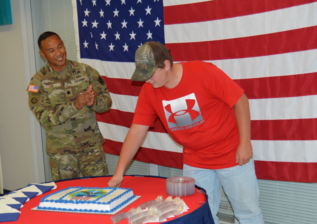 Two people cut a cake at a celebration.