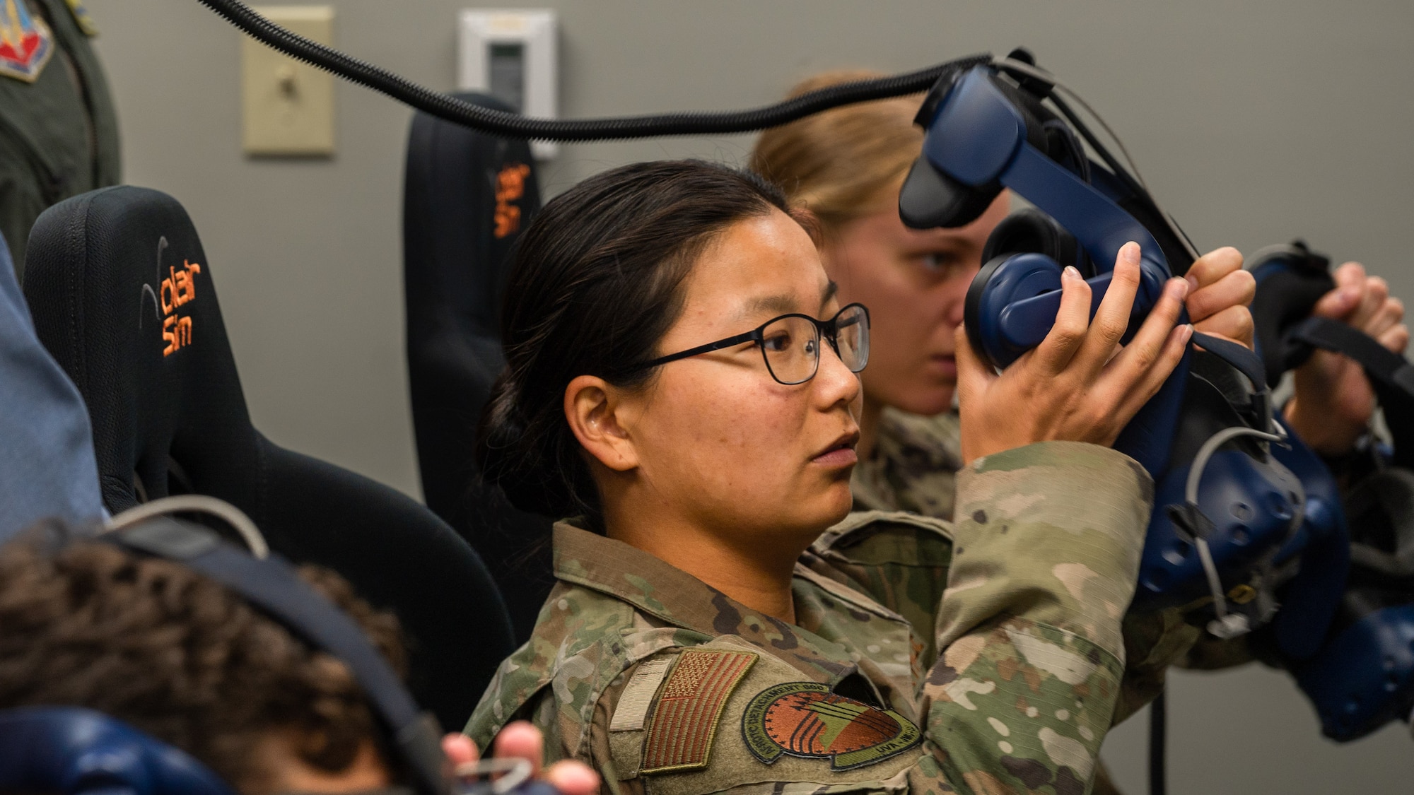 Air Force ROTC Cadet Tony Jade Lewis prepares to fly an F-15E Strike Eagle in a virtual reality training simulation at Seymour Johnson Air Force Base, North Carolina, August 3, 2023. Under the guidance of Capt. Victoria Beck, 334th Fighter Squadron weapons safety officer and Capt. Cecilia “Feisty” Tuma, a pilot assigned to the 333rd Fighter Squadron, the cadets attempted to take-off, attack both airborne and land targets and land during the simulation. (U.S. Air Force photo by Airman 1st Class Leighton Lucero)