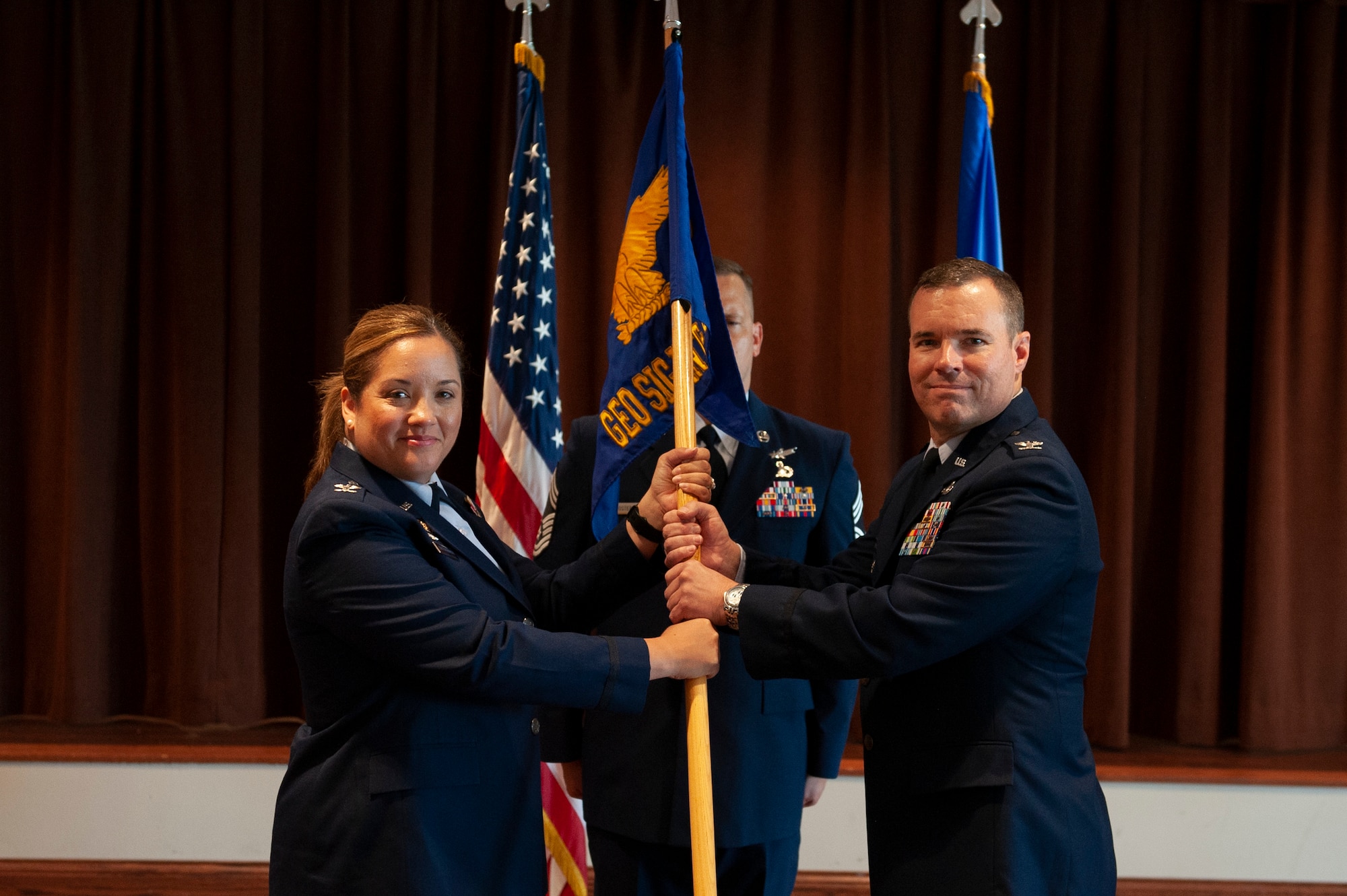 Col. Brandon Shade, incoming Geospatial and Signatures Intelligence Group commander accepts the guidon from Col. Ariel G. Batungbacal, National Air and Space Intelligence Center commander during the groups change of command ceremony at Wright-Patterson Air Force Base, Ohio, July 25, 2023. A change of command is a military tradition that represents a formal transfer of authority and responsibility for a unit from one commanding officer to another.