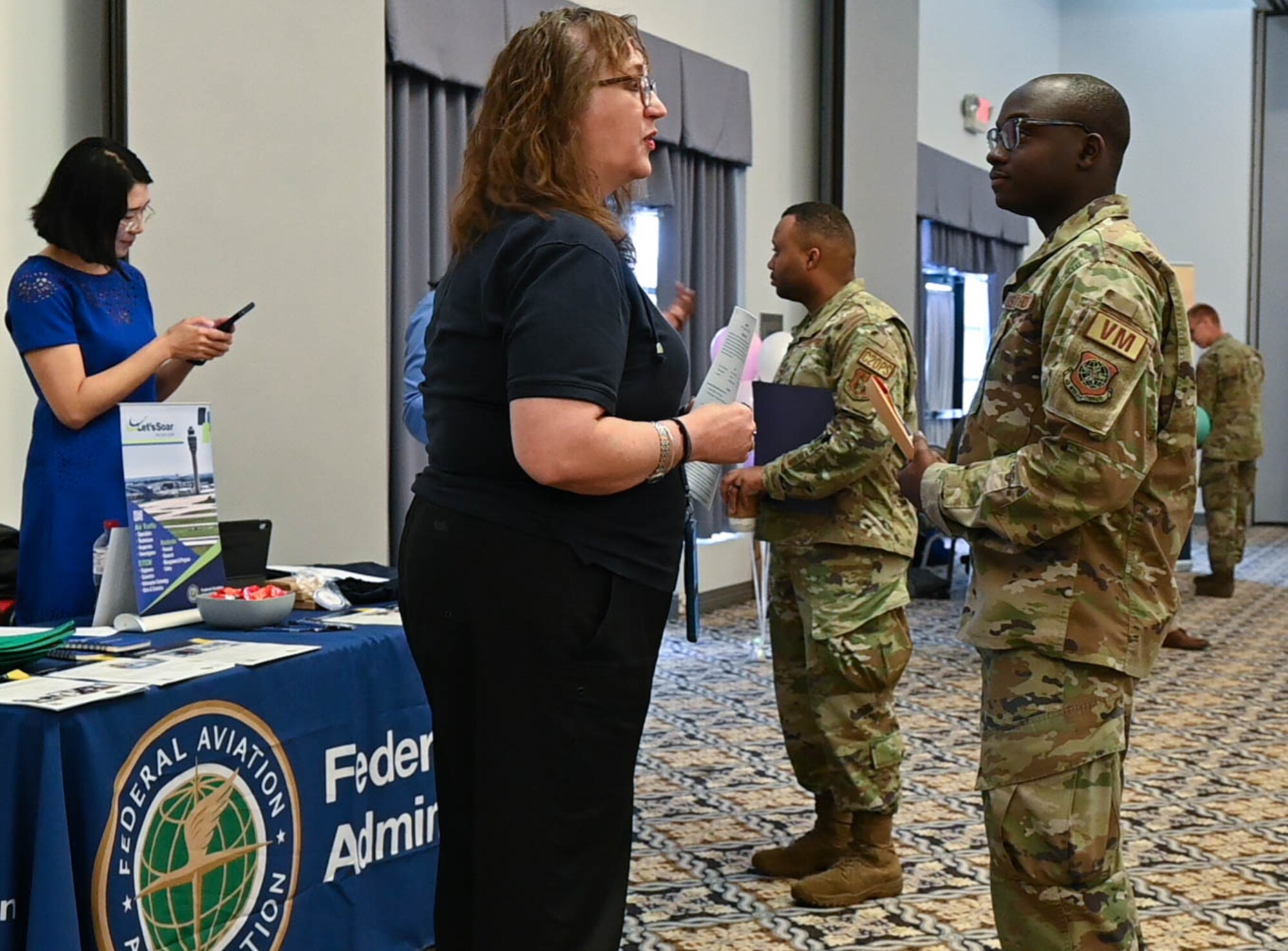 Team Dover Airmen speak with Federal Aviation Administration representatives during the Fly High Career-a-thon Fair  at Dover Air Force Base, Delaware, Aug. 3, 2023. The event gave Airmen an opportunity to network with well-known aviation companies and learn about career opportunities in the industry.