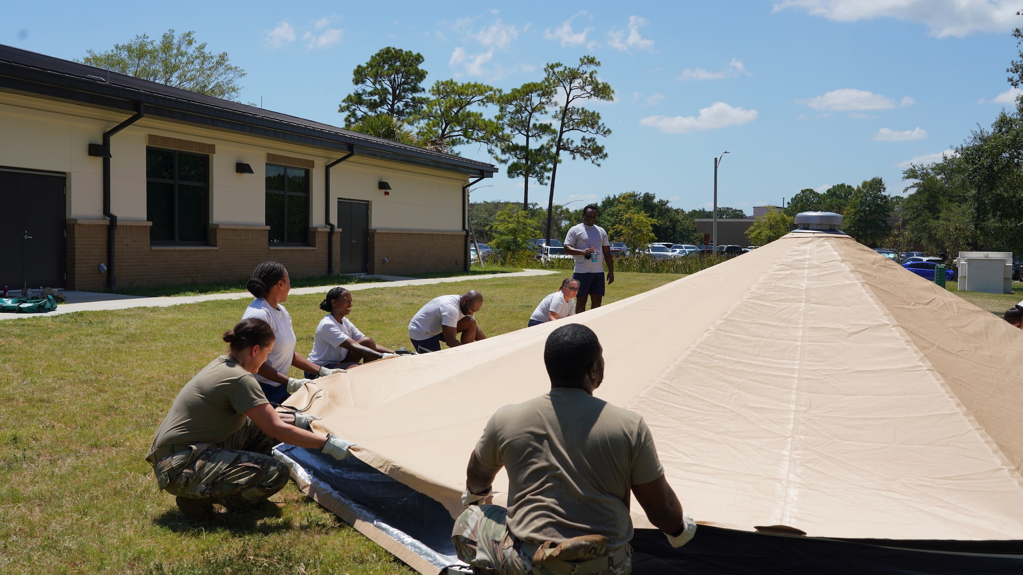 Airmen working together to put a tent.
