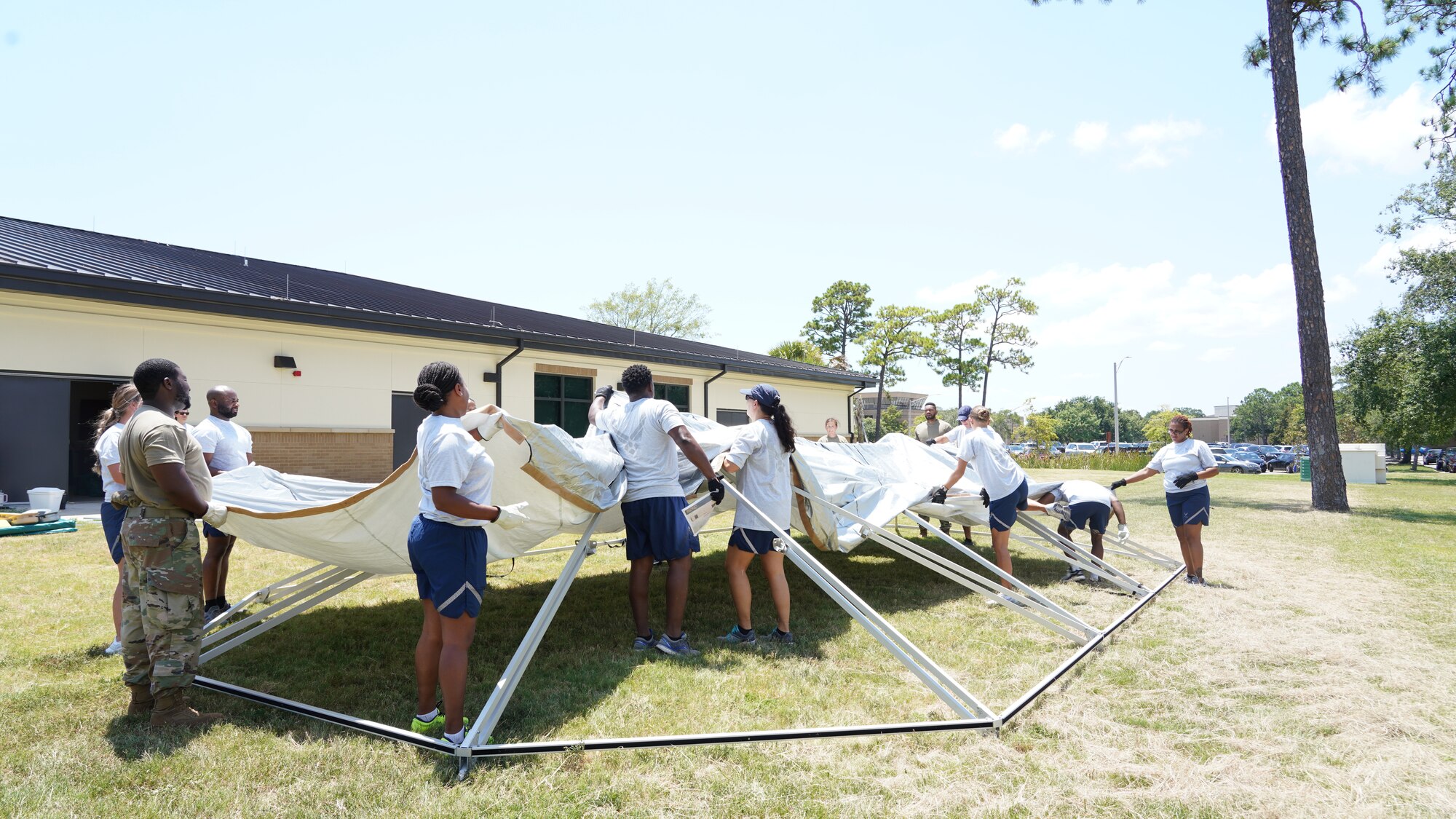 Airmen working together to put a tent.