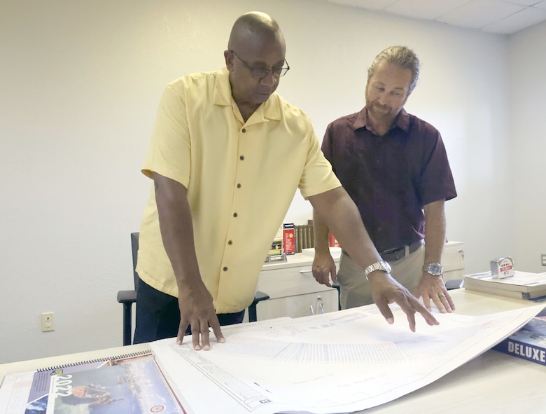 Mark White, U.S. Army Corps of Engineers, Panama City Site office lead civil engineer, plots on a map where they will be surveying next as Waylon Register, Panama City Site office manager, look on at the site office, Panama City, Florida, July 13, 2023. White, who has worked in the Panama City Site Office for almost 40 years, will be retiring in the fall. (U.S. Army photo by Chuck Walker)