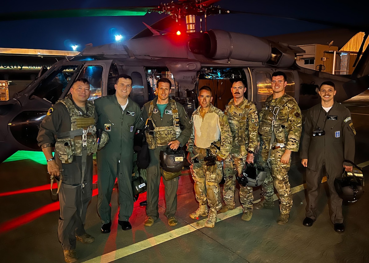 New York Air National Guard and Brazilian airmen pose for a photo by a New York HH-60G Pave Hawk rescue helicopter assigned to the 106th Rescue Wing before a mission Aug. 26, 2022, during Operation Tapio 22 in  Campo Grande, Brazil.