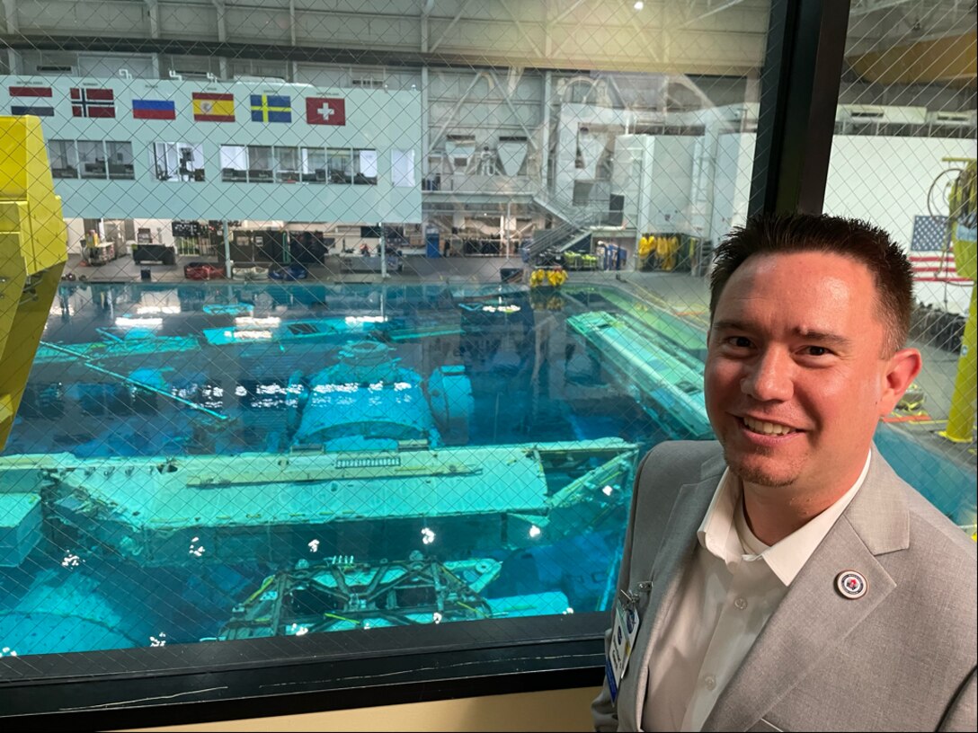 Justin McRoberts, program manager for the DoD Manufacturing Science and Technology Program, stands over the indoor pool of NASA's Buoyancy Lab at Johnson Space Center. This pool acts as a training environment for astronauts working on the International Space Station mission. (DoD photo by Alex Chesney)
