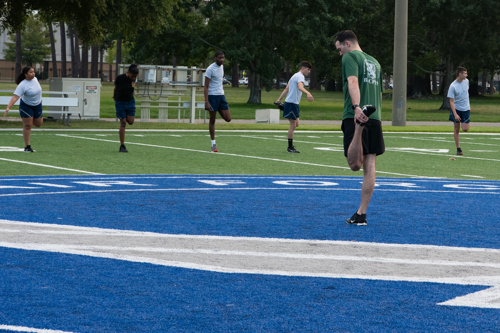 U.S. Air Force Staff Sgt. Cody Moss, 81st Comptroller Squadron unit deployment manager, leads members of the 81st CPTS and the 81st Communications Squadron through warm-ups on the Multi-Purpose Turf Field at Keesler Air Force Base, Mississippi, July 28, 2023.