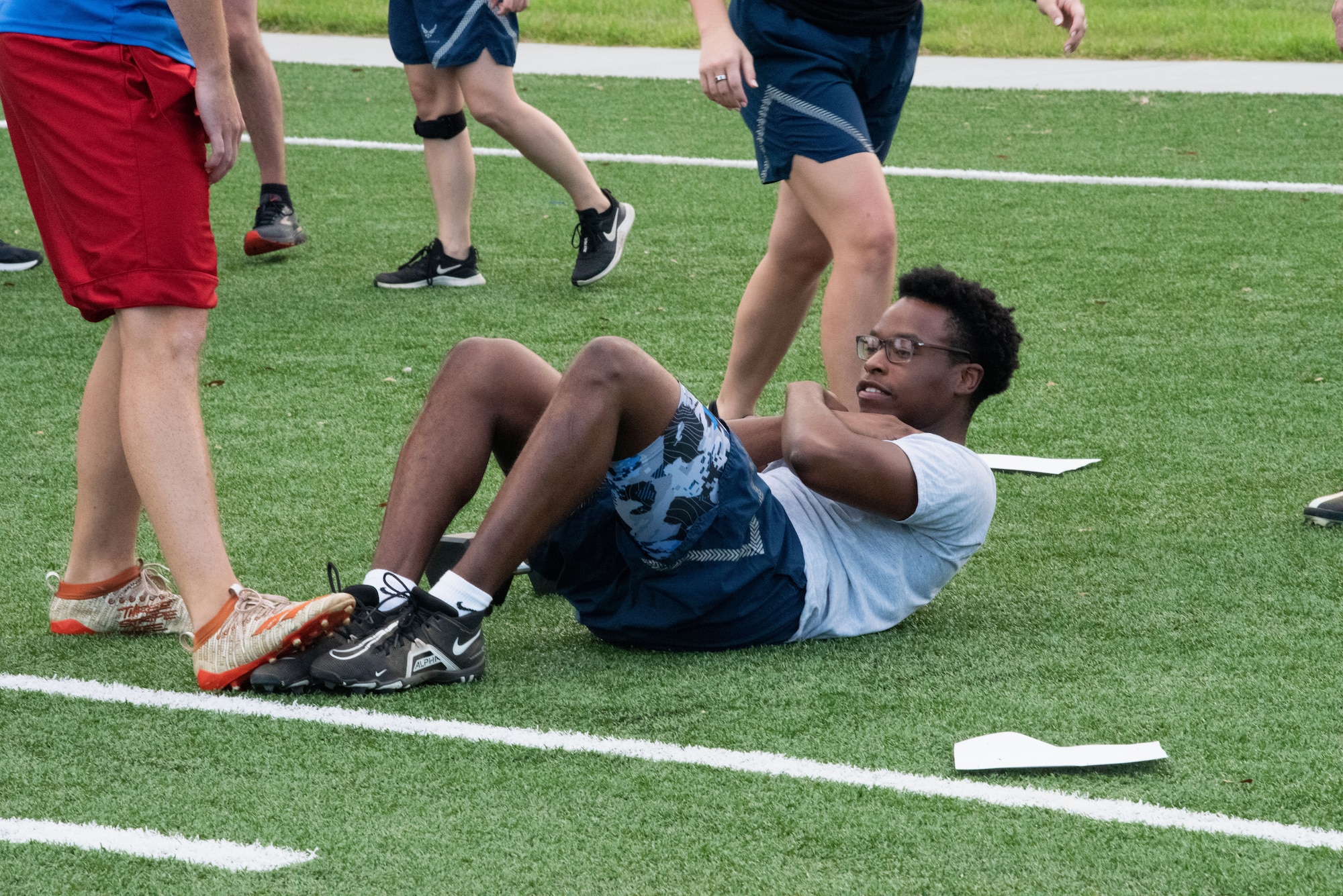 U.S. Air Force Senior Airman Devin Louder, 81st Communications Squadron client systems technician supervisor, performs sit-ups at the Multi-Purpose Turf Field on Keesler Air Force Base, Mississippi, July 28, 2023.