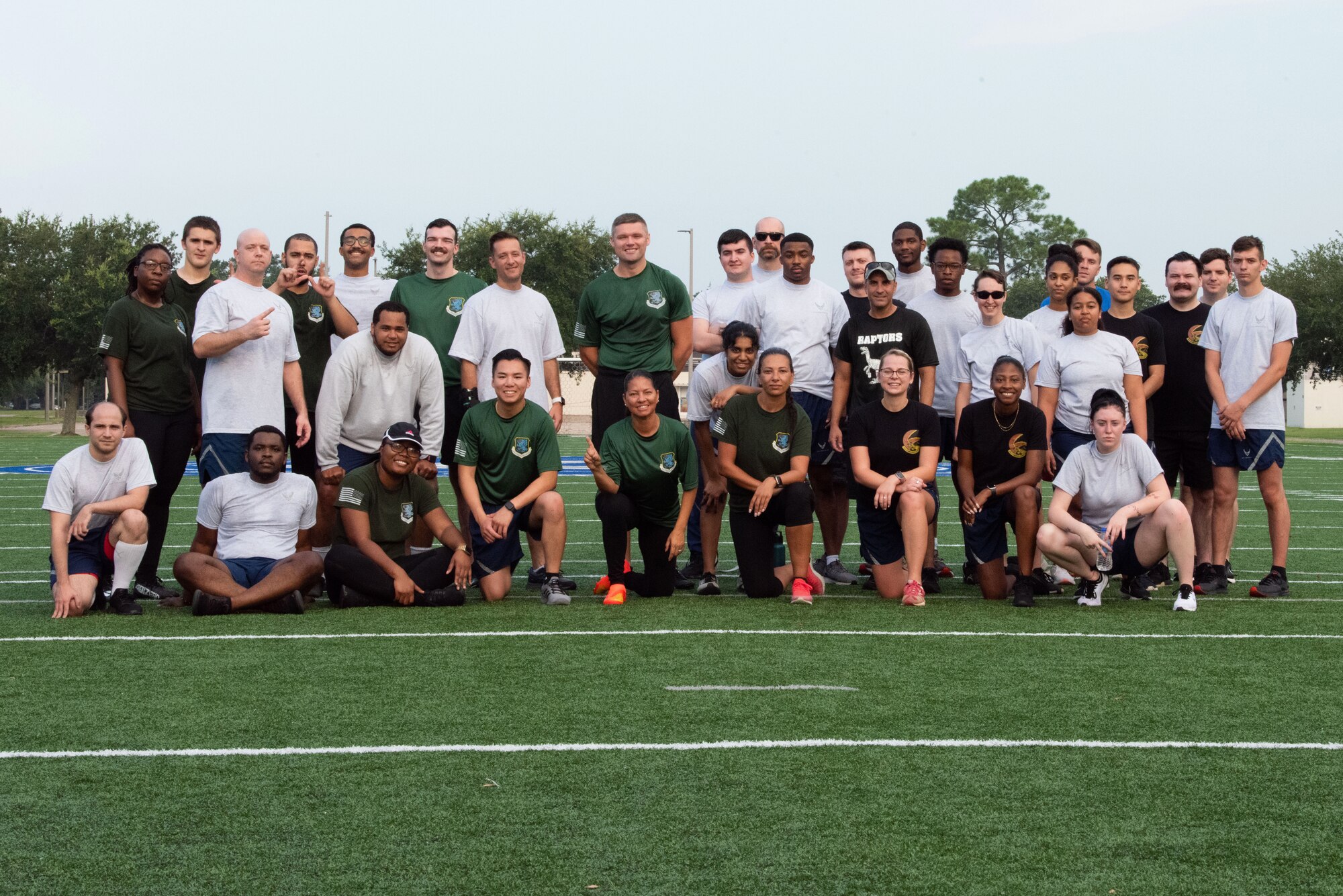 The 81st Comptroller Squadron and the 81st Communications Squadron pose for a group photo on the Multi-Purpose Turf Field at Keesler Air Force Base, Mississippi, July 28, 2023.