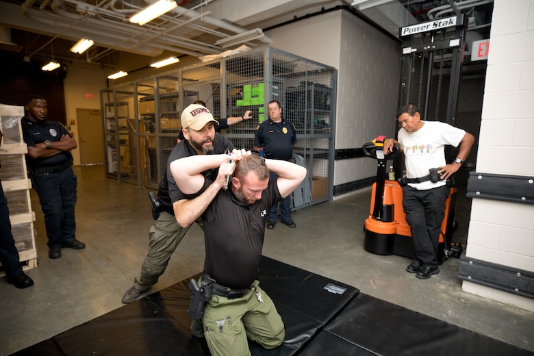 Lt. Michael Kelly, from the Clinton Police Department, demonstrates a cuffing maneuver on fellow officer Dustin McNolan to members of the U.S. Army Engineer Research and Development Center (ERDC) security force during Police Subject Control training that took place at ERDC in May.