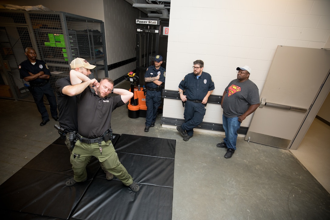 Lt. Michael Kelly, from the Clinton Police Department, demonstrates a cuffing maneuver on fellow officer Dustin McNolan to members of the U.S. Army Engineer Research and Development Center (ERDC) security force during Police Subject Control training that took place at ERDC in May.