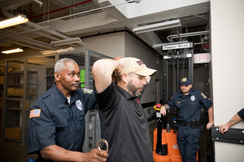 Morris Lovette, a U.S. Army Engineer Research and Development Center (ERDC) security guard, prepares to cuff Lt. Michael Kelly from the Clinton Police Department during Police Subject Control training that took pla