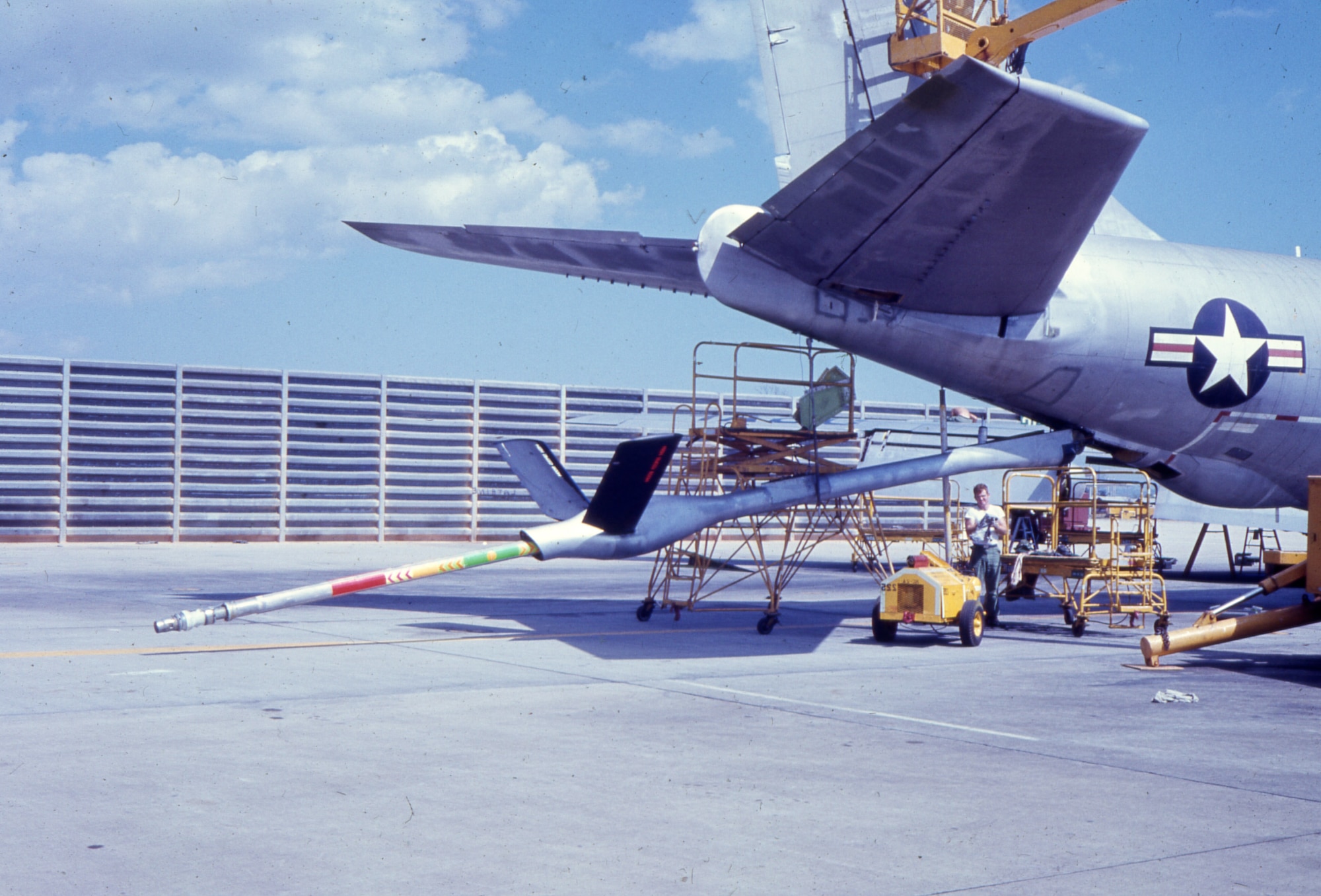 In this photo, the flying boom is lowered and extended during routine maintenance. The black ruddervators are angled upward from the middle of the boom.