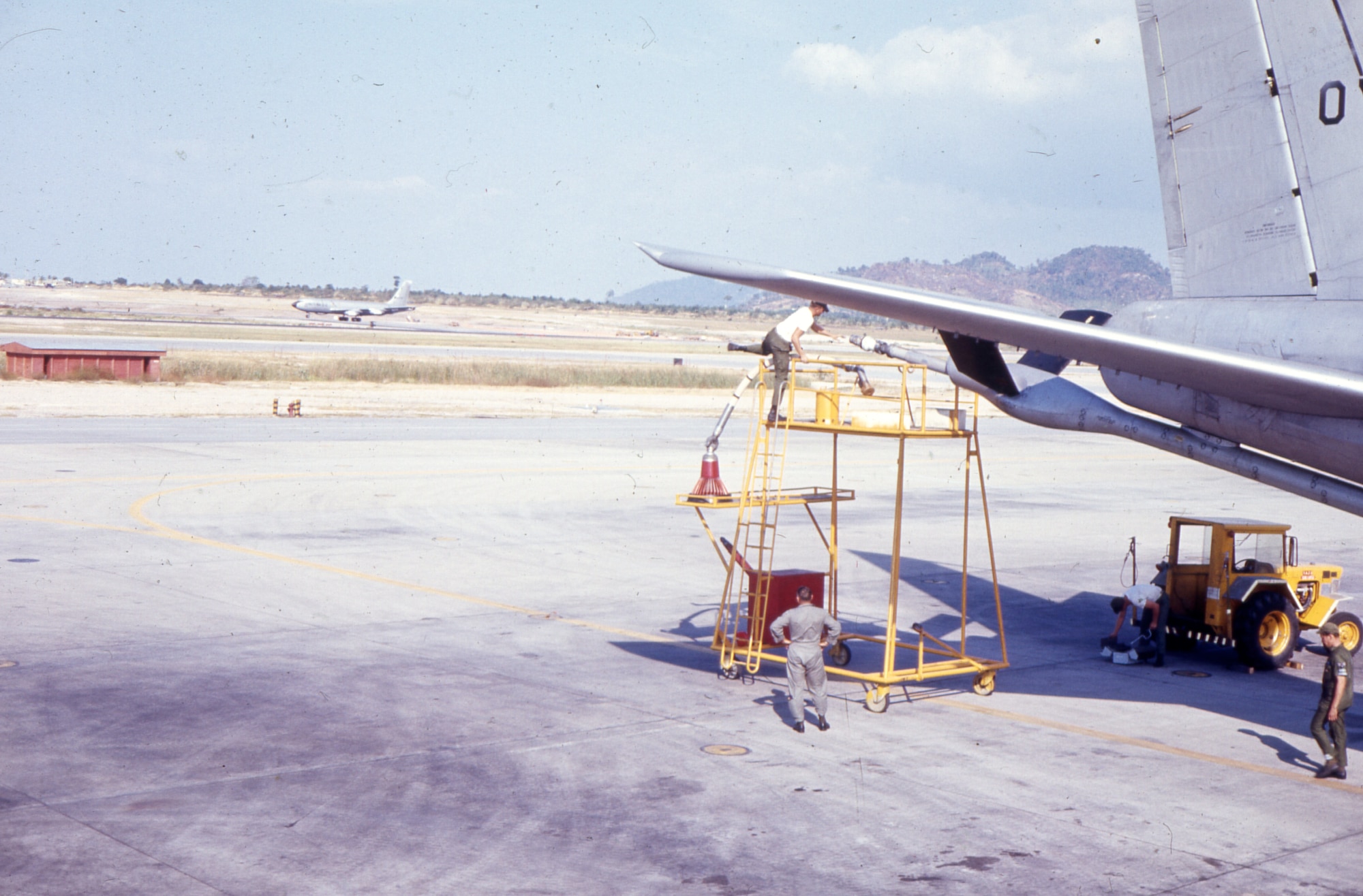 A boom operator attaches a drogue to the boom of a KC-135 during the Southeast Asia War. The drogue is the red cone-shaped attachment you see here, used to refuel aircraft that have a probe instead of a receptacle.