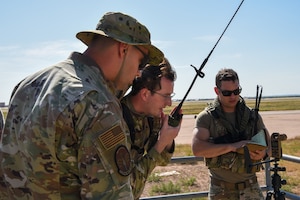 Tech. Sgt. Nicholas Goldsmith, 7th Operations Support Squadron radar and weather systems NCO in charge, and Staff Sgt. Ryan Jordin, 7th Operations Support Squadron air traffic controller, use a mobile radio to communicate with the C-130J Super Hercules at Dyess Air Force Base, Texas, Aug. 2, 2023. The course is a major priority and focal point of future airfield operations, meeting the intent of Agile Combat Employment and Multi-Capable Airmen concepts while improving combat-oriented training. (U.S. Air Force photo by Senior Airman Sophia Robello)