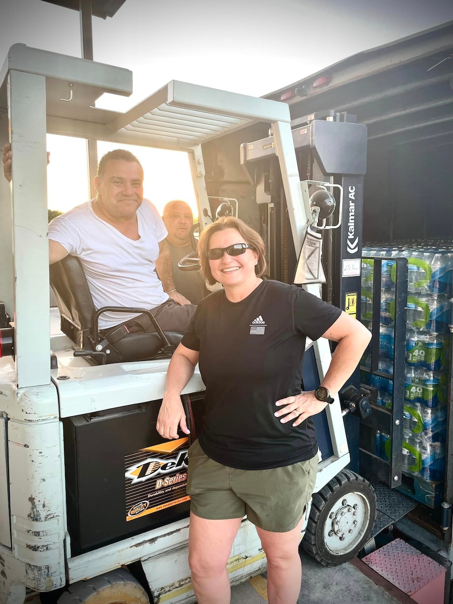 U.S. Air Force Col. Angelina Maguinness, 17th Training Wing commander, (right)  Marco Espinoz,17th Logistics Readiness Squadron distribution section chief, (left) and Dustin Bresko, 17th LRS munitions inspector, (center) offload pallets of water at Goodfellow Air Force Base, Texas, July 19th, 2023. Outside of their hours of operation, members of the 17th LRS personnel immediately responded to the boil-water advisory for Goodfellow.  (Courtesy photo)