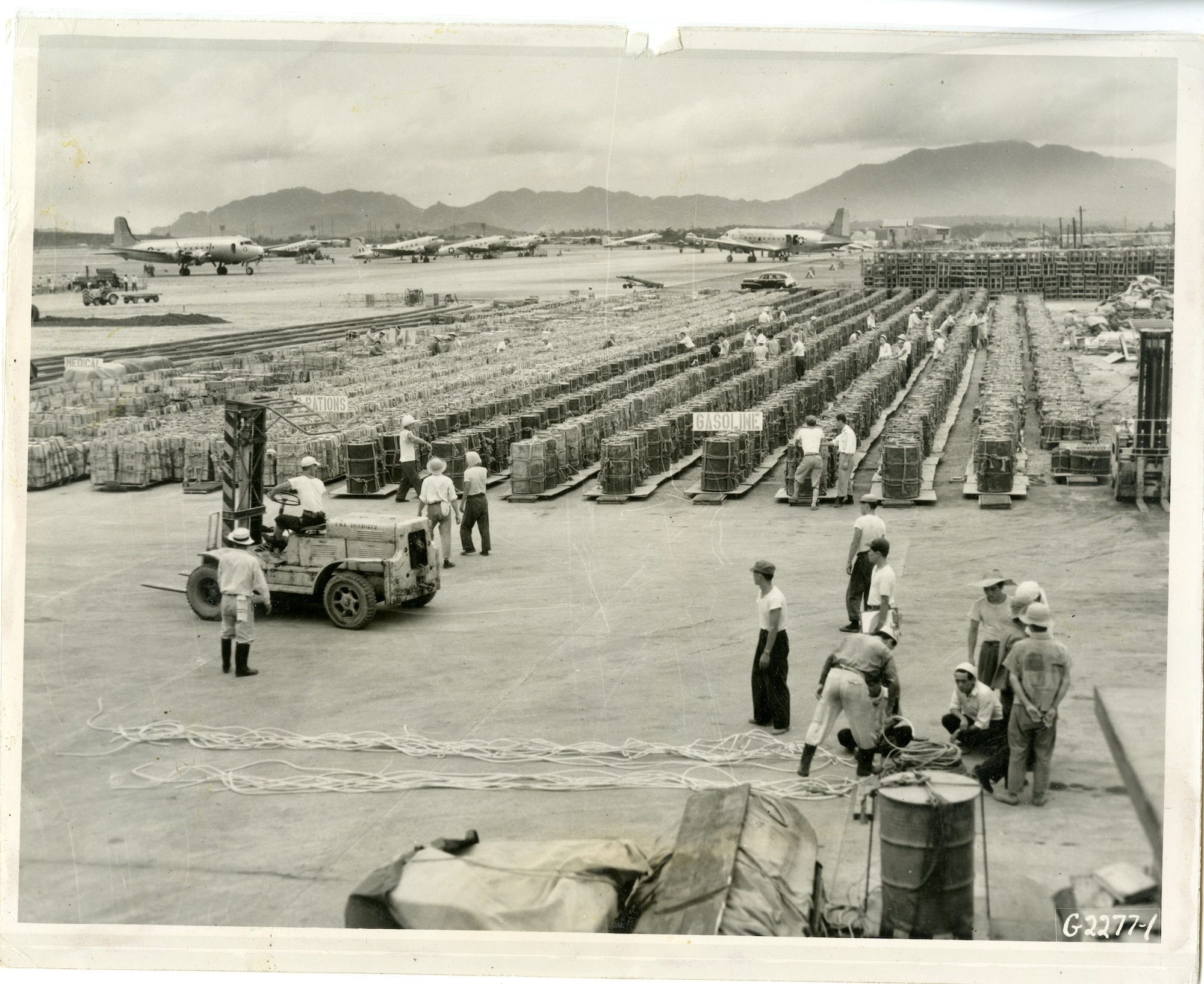 Long rows of gasoline, C-rations, napalm tanks, and medical supplies