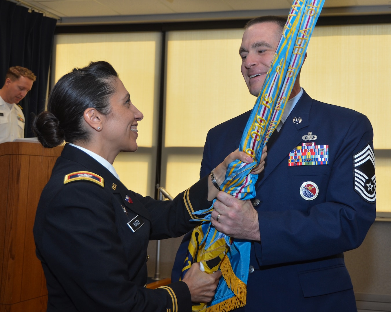 Air Force Chief Master Sgt. Daniel Kenemore, the new senior enlisted advisor (SEA) of USMEPCOM Eastern Sector, receives the unit’s colors and symbolically accepts his new role during a ceremony, Aug. 10, at USMEPCOM headquarters in North Chicago, Illinois. Kenemore received responsibility from Army Col. Janelle Kutter, during the ceremony.