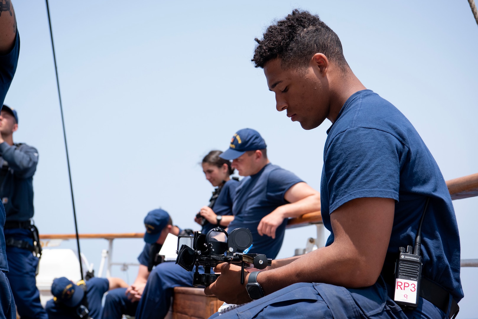 Coast Guard Academy Cadet Tristan Carbonell learns about navigational tools aboard USCGC Eagle (WIX 327), June 28, 2023, while underway in the Atlantic Ocean. The officers-to-be complete required seamanship for eventual commissioning as officers in the United States Coast Guard (U.S. Coast Guard photo by Petty Officer 3rd Class Carmen Caver)