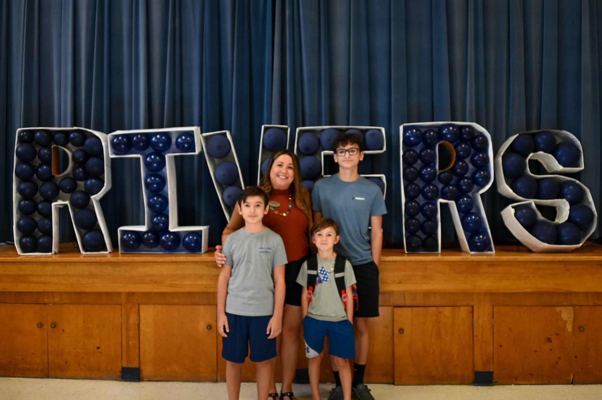 Gwendolyn Brakebill, 97th Force Support Squadron school liaison program manager, poses in front of an L. Mendel Rivers balloon display at Altus Air Force Base, Oklahoma, Aug. 7, 2023. Brakebill has three sons with her husband who also works on-base with the C-17 Globemaster III loadmaster simulators. (U.S. Air Force photo by Airman 1st Class Kari Degraffenreed)