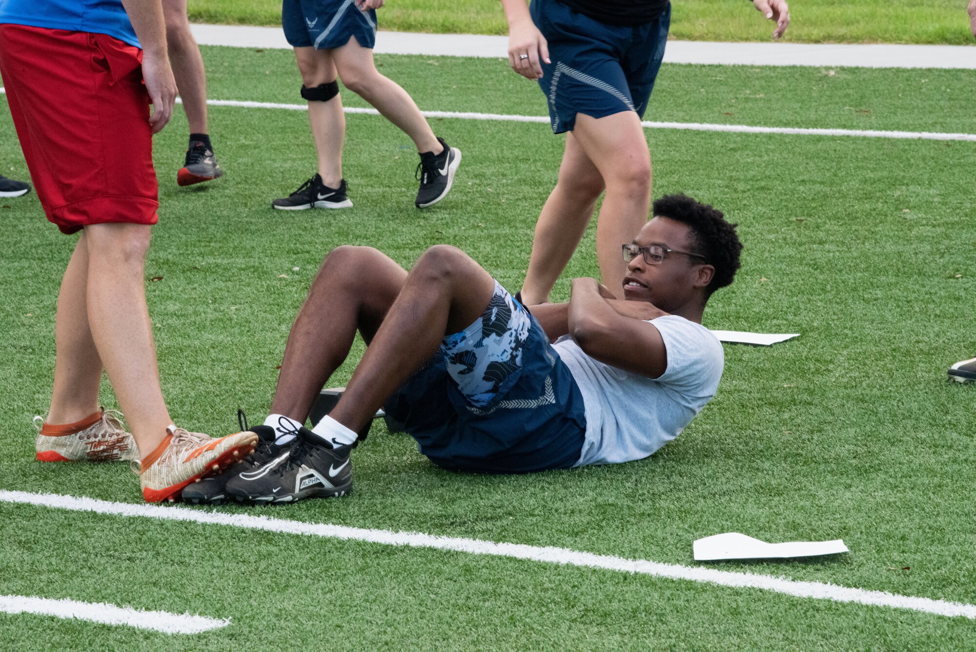 U.S. Air Force Senior Airman Devin Louder, 81st Communications Squadron client systems technician supervisor, performs sit-ups at the Multi-Purpose Turf Field on Keesler Air Force Base, Mississippi, July 28, 2023.
