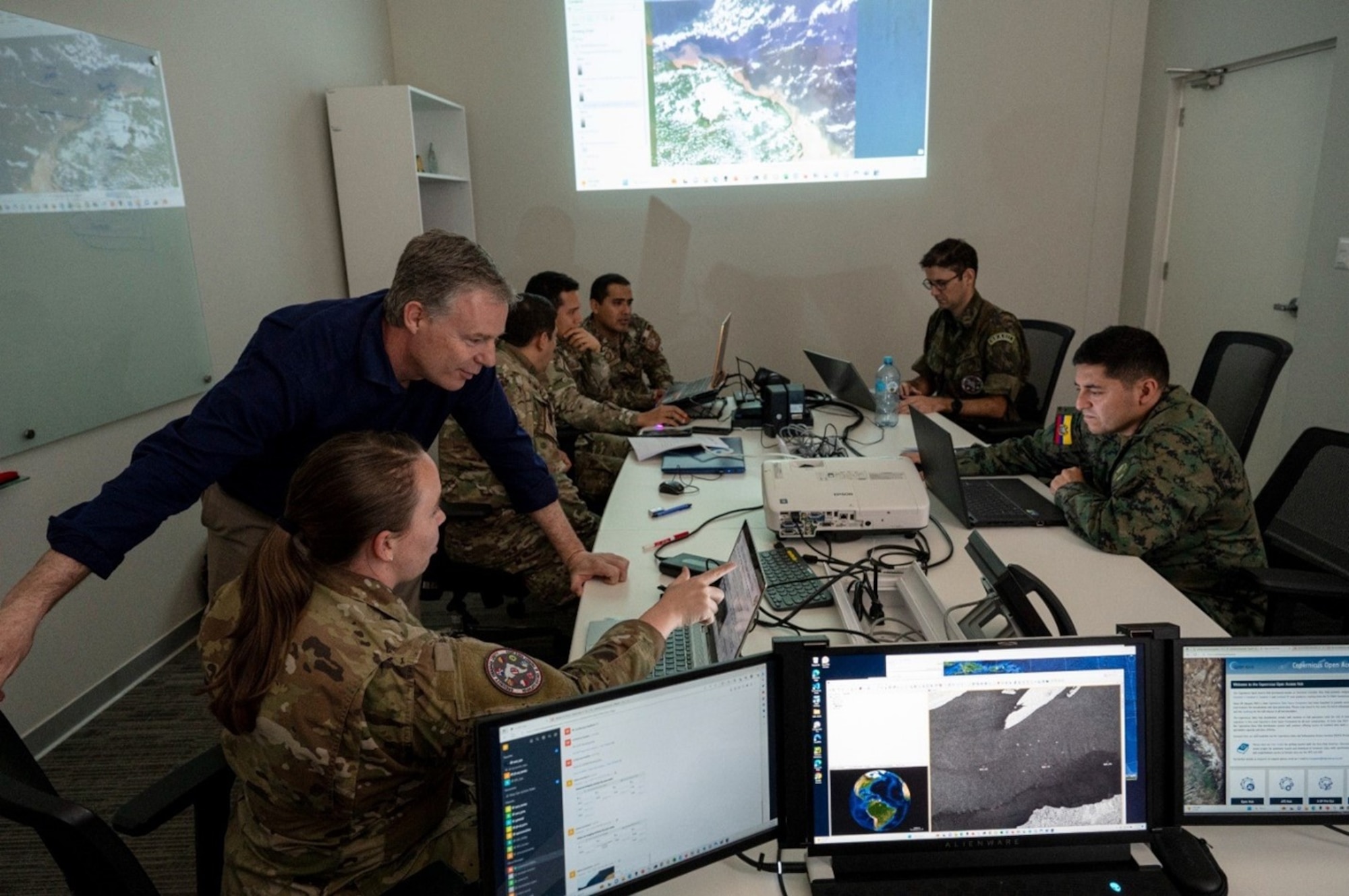 1st Lt. McKenna Medina and Joseph Gerber, JCO Integration, discuss updates to the Illegal Fishing Operational Planning Products during daily operations. Photo credit: SSgt, Matthew Matlock