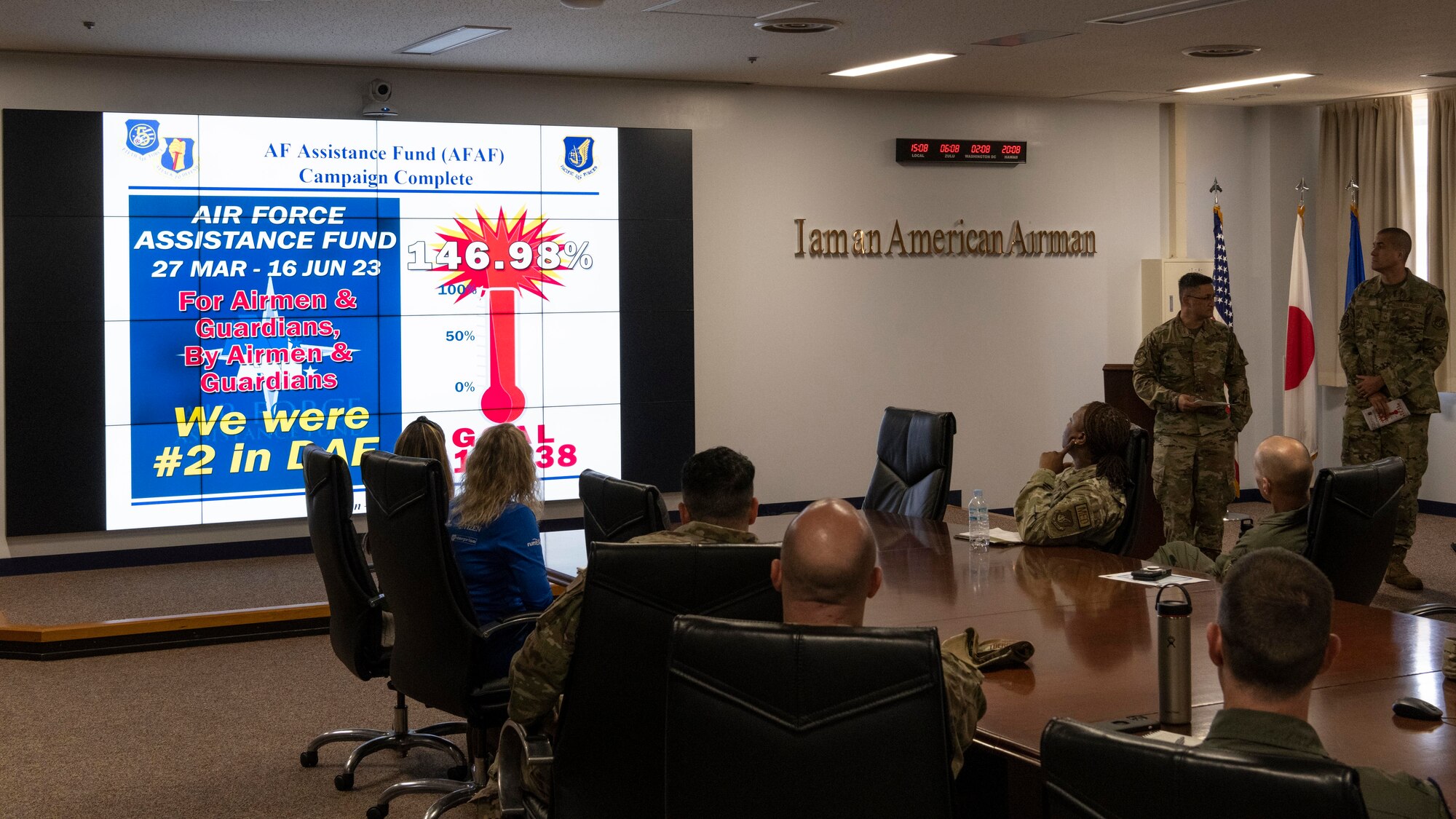 Two military members give a presentation in a conference room.