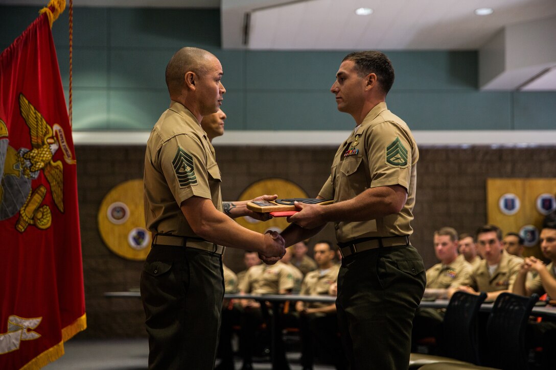 U.S. Marine Staff Sgt. Presten Gabaldon, right, a student with the Marine Combat Instructor School, School of Infantry - West, receives the “Gung-Ho” award during the graduation ceremony for Class 4-19 on Marine Corps Base Camp Pendleton, California, Sept. 12, 2019. The mission of CIS is to develop Marines’ leadership, character, knowledge and fitness to fortify them with skills required to succeed as a combat instructors. CIS is a nine-week course that provides Marines with knowledge of the rules, regulations and procedures to prepare them to lead and instruct entry-level Marines during combat training. (U.S. Marine Corps photo by Lance Cpl. Alison Dostie)