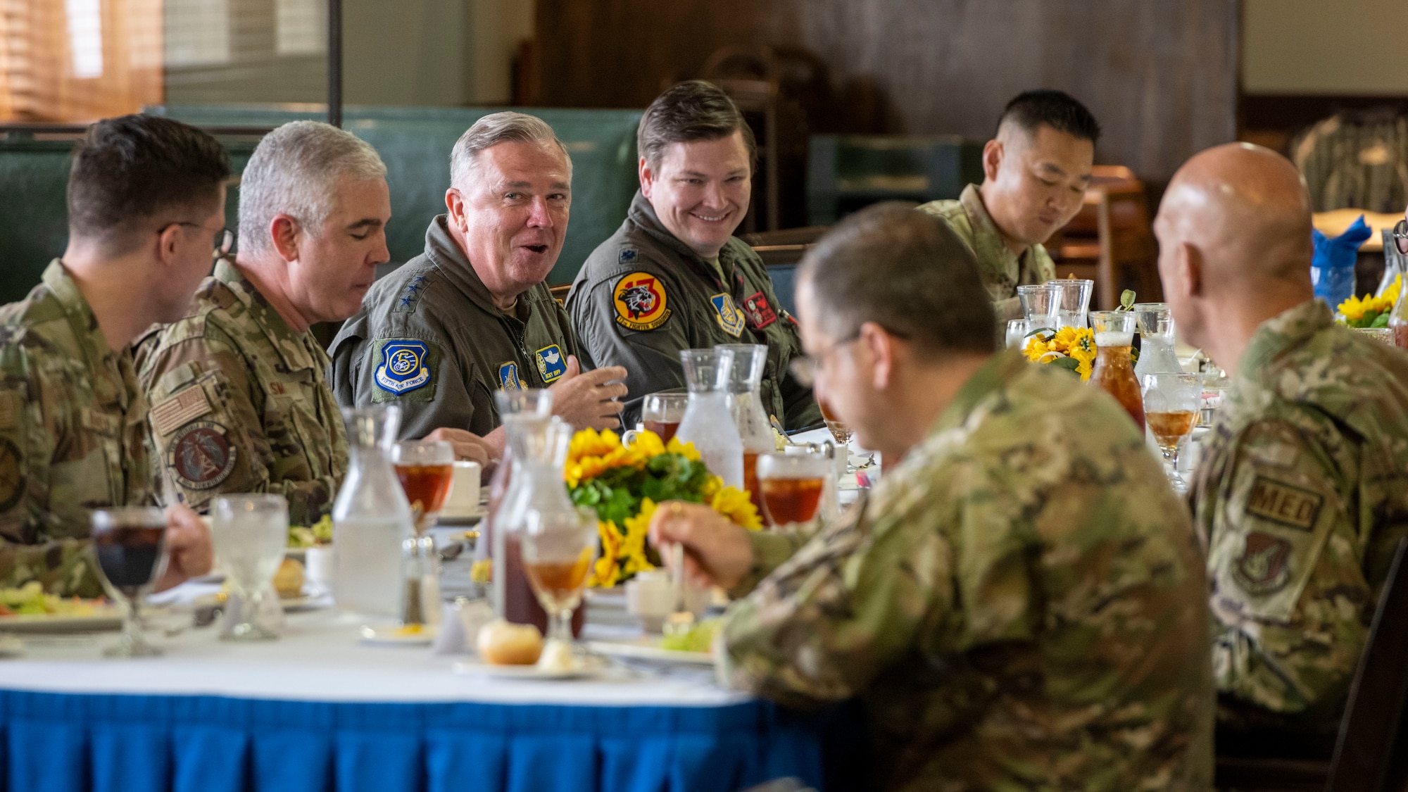 Military members conversating during lunch with one another.