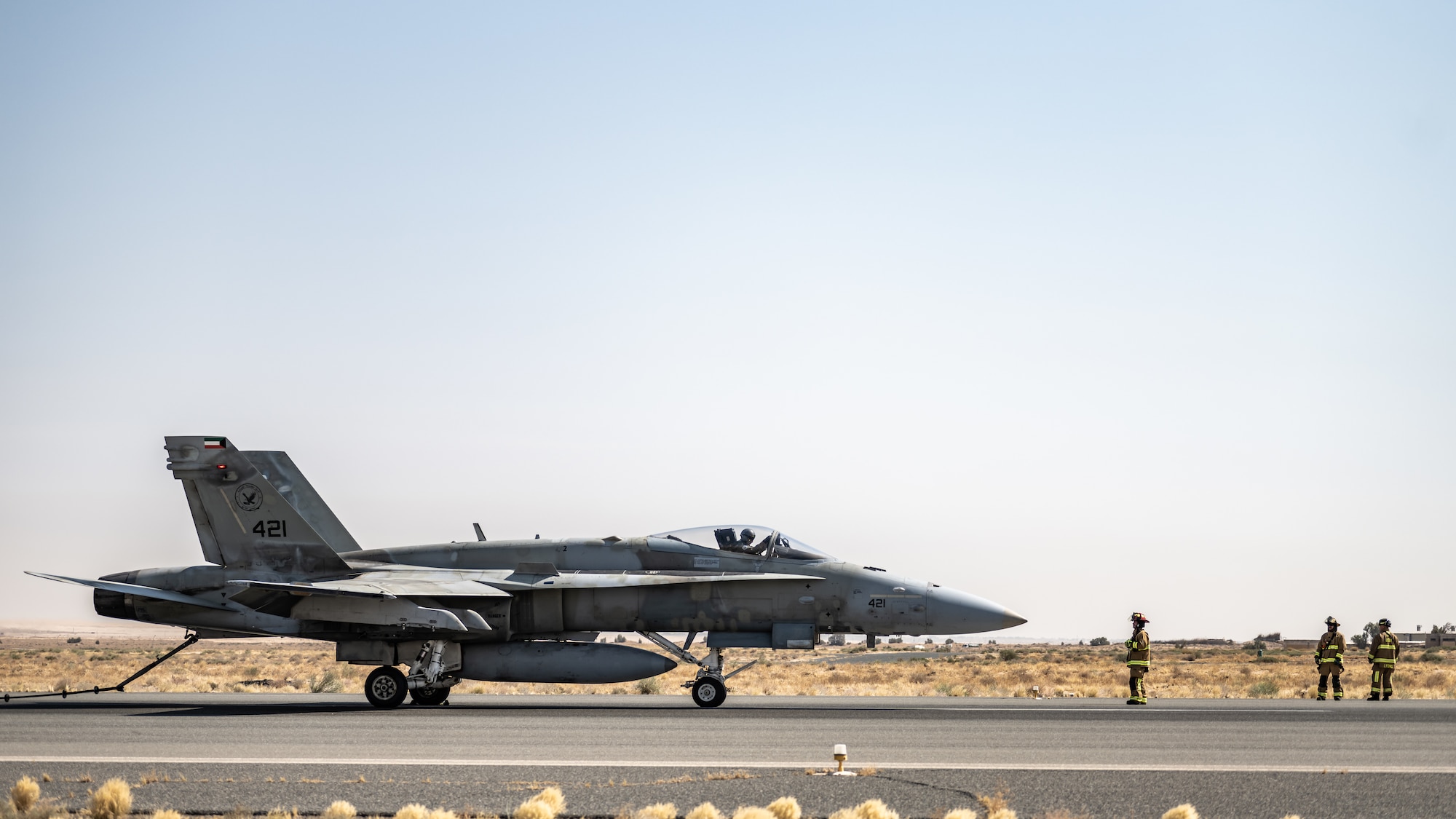 U.S. Air Force fire protection Airmen assigned to the 386th Expeditionary Civil Engineer Squadron prepare to disconnect a Kuwait Air Force F/A-18 Super Hornet from a Mobile Aircraft Arresting System (MAAS) at Ali Al Salem Air Base, Kuwait, July 10, 2023. This certification event was beneficial to the U.S. and Kuwait as both parties received more experience using the MAAS, which has been certified to continue providing enhanced stopping power to inbound aircraft for a variety of scenarios. (U.S. Air Force photo by Staff Sgt. Kevin Long)