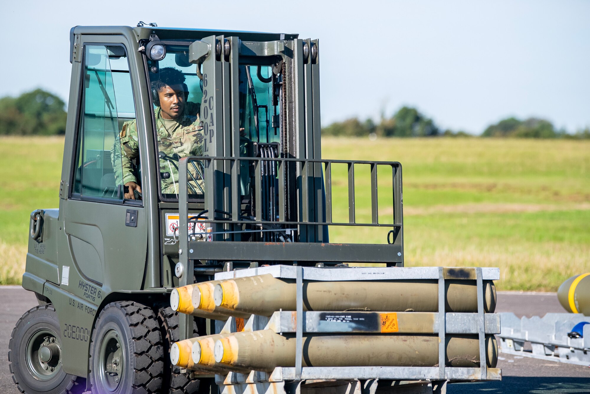 An Airman from the 48th Fighter Wing transports munitions at RAF Fairford, England, Aug. 10, 2023. Members from the 48th FW, 501st Combat Support Wing, 28th Bomb Wing and Royal Air Force conducted munitions builds and transports in support of a week-long Combat Ammunition Production Exercise. The exercise provided them an opportunity to evaluate munitions combat readiness, base support plan adequacy, tactics, techniques and procedures and enhanced interoperability between NATO forces. (U.S. Air Force photo by Staff Sgt. Eugene Oliver)