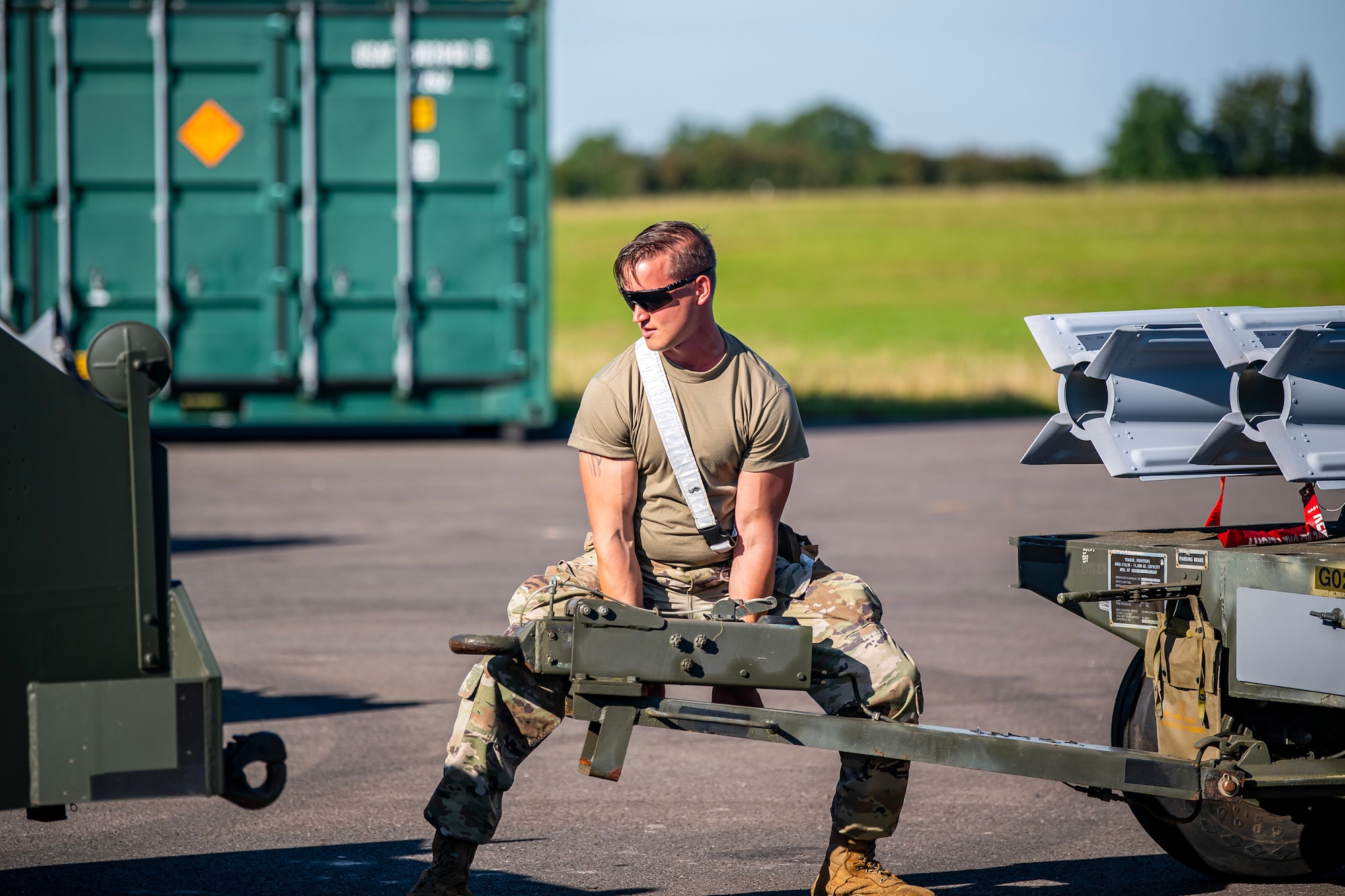 A U.S. Air Force Airman connects a munitions trailer to a truck at RAF Fairford, England, Aug. 10, 2023. Members from the 48th Fighter Wing, 501st Combat Support Wing, 28th Bomb Wing and Royal Air Force conducted munitions builds and transports in support of a week-long Combat Ammunition Production Exercise. The exercise provided them an opportunity to evaluate munitions combat readiness, base support plan adequacy, tactics, techniques and procedures and enhanced interoperability between NATO forces. (U.S. Air Force photo by Staff Sgt. Eugene Oliver)