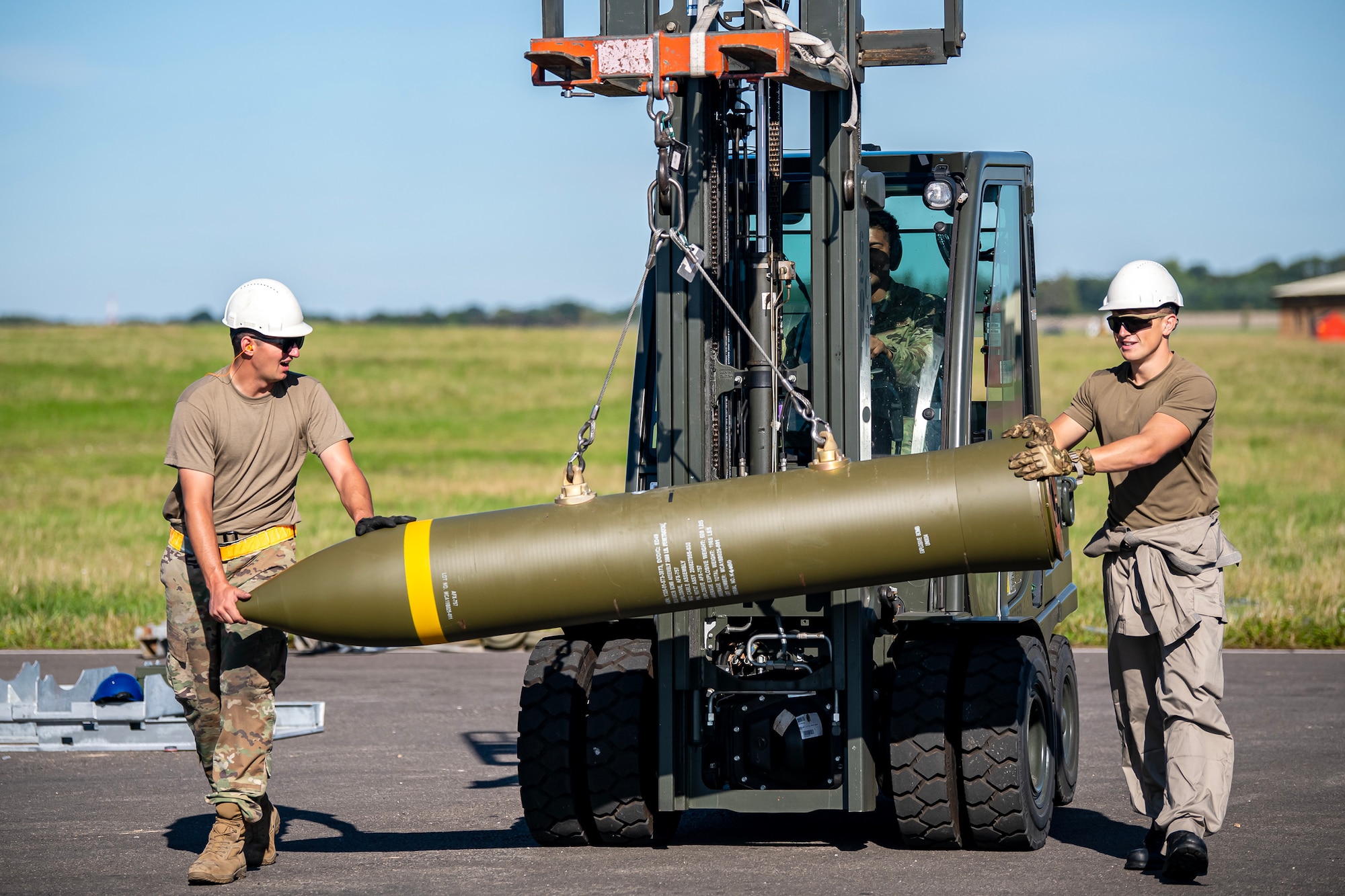 Members from the U.S. and Royal Air Force transport a muntion at RAF Fairford, England, Aug.10, 2023. Members from the 48th Fighter Wing, 501st Combat Support Wing, 28th Bomb Wing and Royal Air Force conducted munitions builds and transports in support of a week-long Combat Ammunition Production Exercise. The exercise provided them an opportunity to evaluate munitions combat readiness, base support plan adequacy, tactics, techniques and procedures and enhanced interoperability between NATO forces. (U.S. Air Force photo by Staff Sgt. Eugene Oliver)