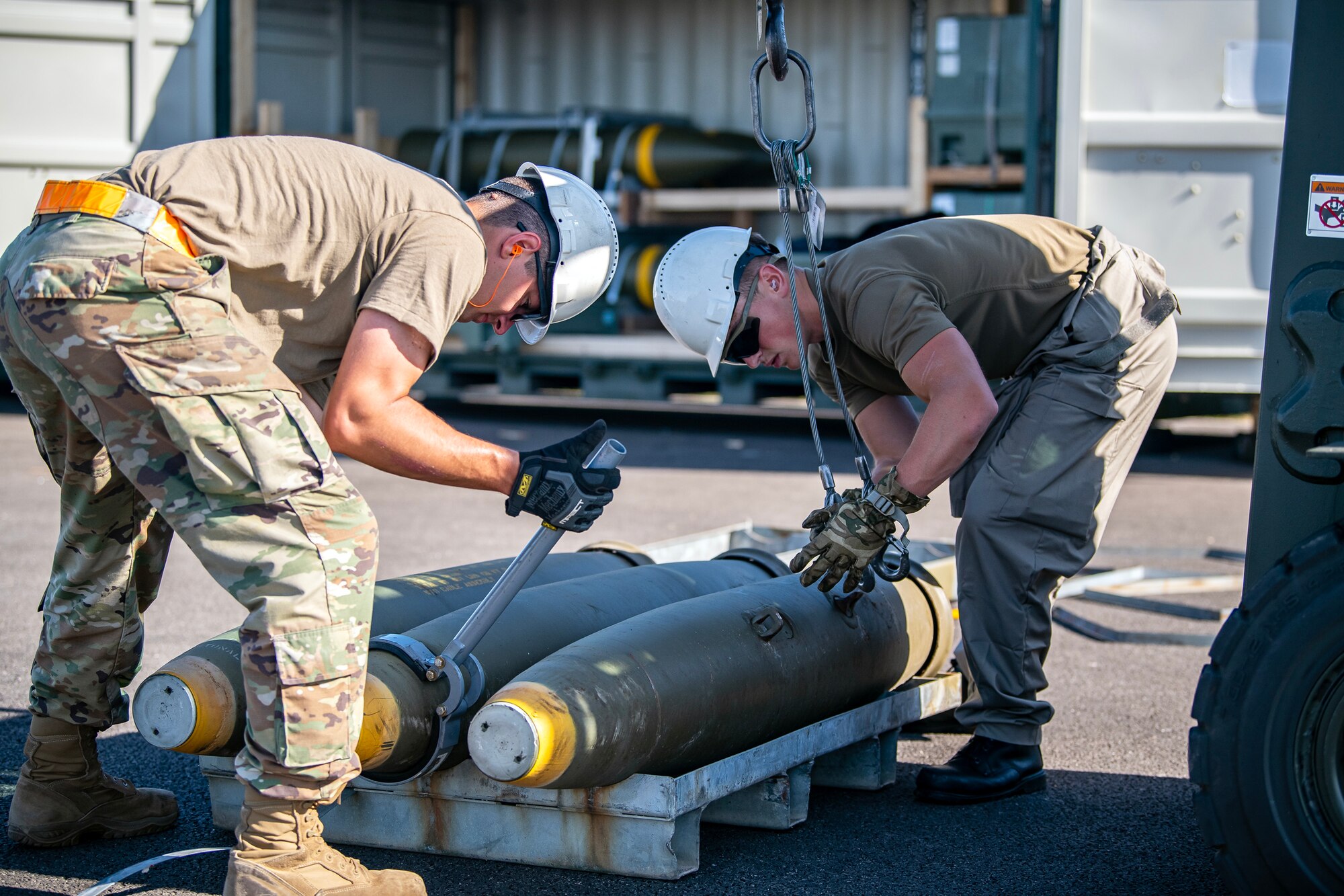 Members from the U.S. and Royal Air Force transport a muntion at RAF Fairford, England, Aug.10, 2023. Members from the 48th Fighter Wing, 501st Combat Support Wing, 28th Bomb Wing and Royal Air Force conducted munitions builds and transports in support of a week-long Combat Ammunition Production Exercise. The exercise provided them an opportunity to evaluate munitions combat readiness, base support plan adequacy, tactics, techniques and procedures and enhanced interoperability between NATO forces. (U.S. Air Force photo by Staff Sgt. Eugene Oliver)